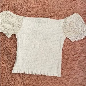 Off the shoulder is white crop top with ruffles